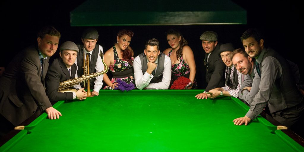 Phil Lyons and the New Vintage band in front of pool table