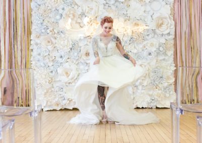 Quirky Yorkshire Wedding Venue River Mills Ballroom tattooed bride in front of flower wall